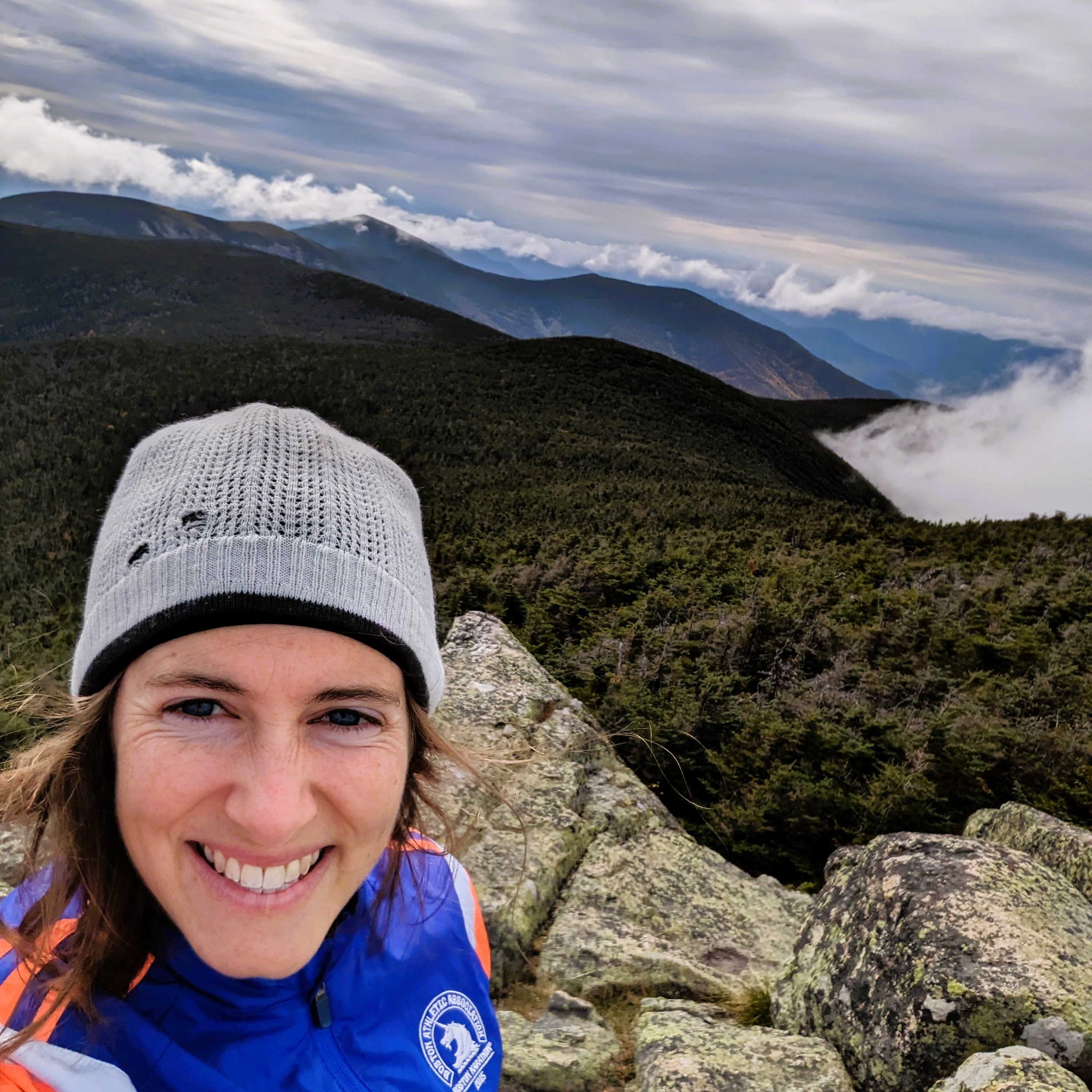 Selfie of the author, a 31-yr-old woman, in front of a mountain view with clouds in the background