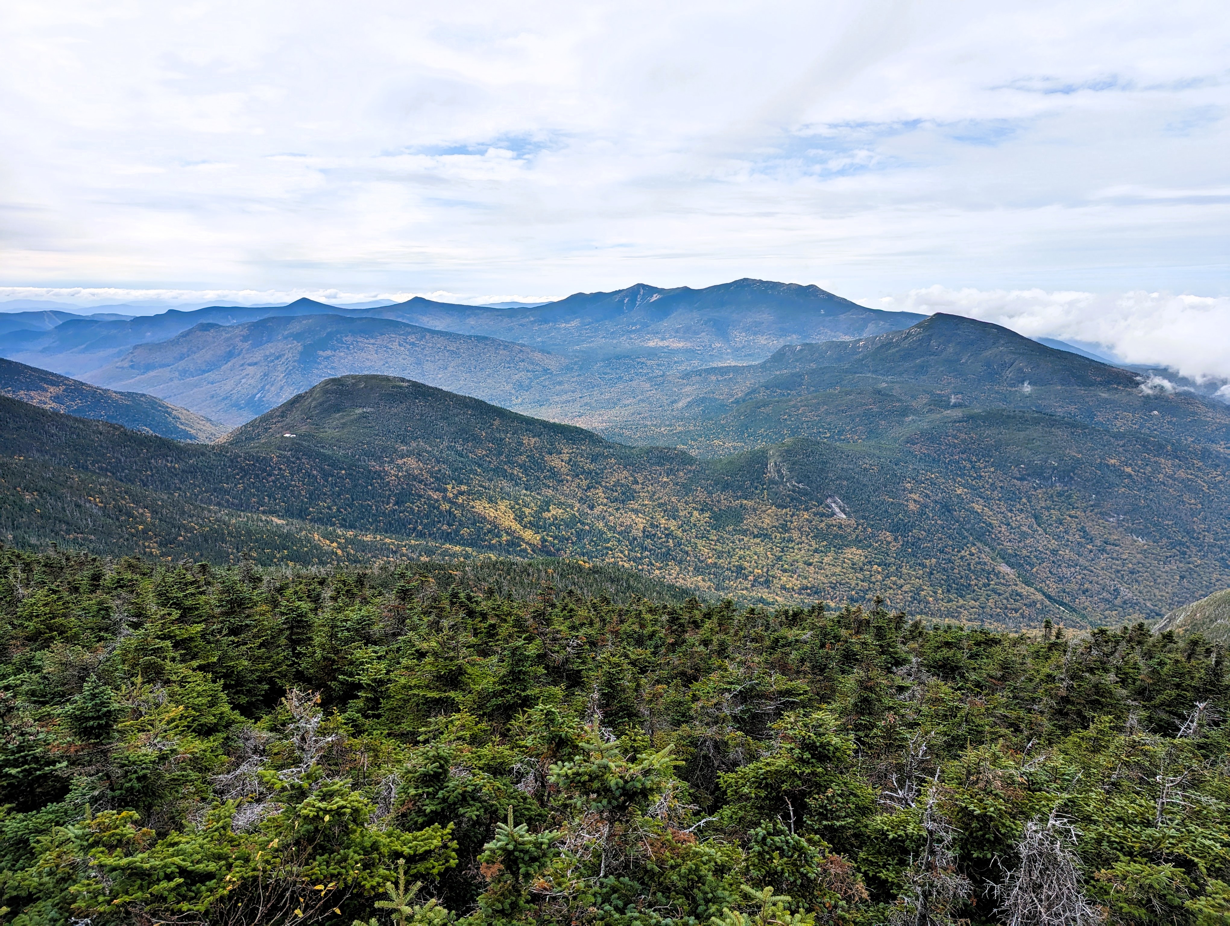 Blue and green mountains under a cloudy sky.